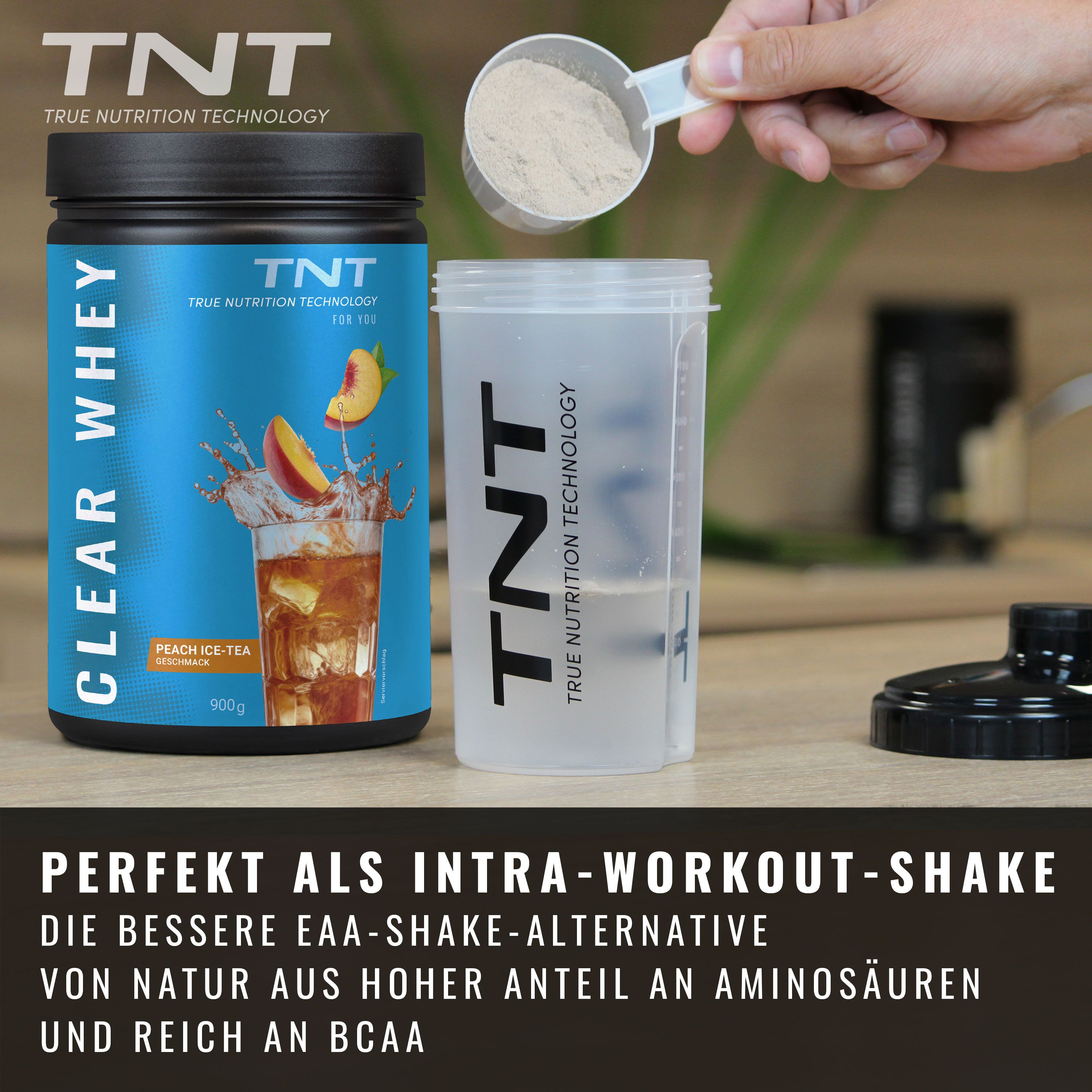 Dose TNT CLEAR WHEY neben Shaker und Messlöffel. Abgebildet: Pfirsich-Eistee. Text: Intra-Workout-Shake, reich an Aminosäuren.