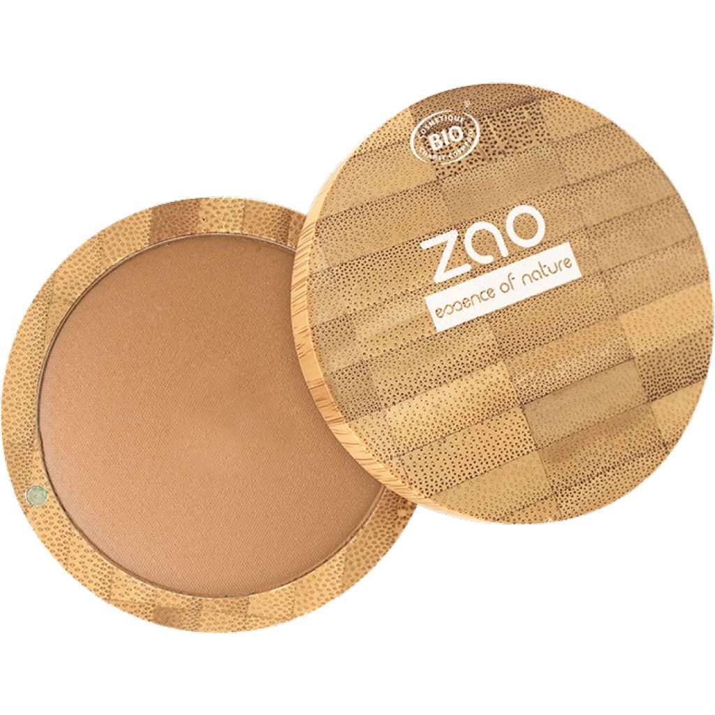 Runder, brauner Puder in einer geöffneten, runden Bambus-Verpackung. Deckel mit Logo und Bio-Siegel. "ZAO essence of nature" steht auf dem Deckel.