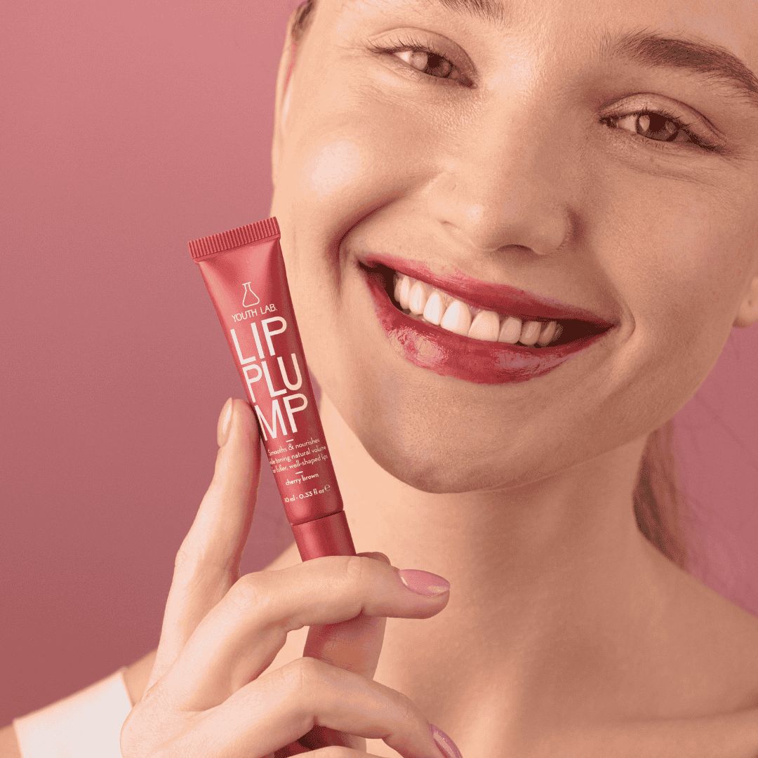 YOUTH LAB Lip Plump, Kirschbraun. Rote Tube, Schriftzug. Frau lächelt, Lippen geschminkt.