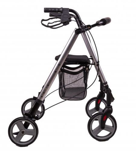 Rollator aus Aluminium mit vier Rädern, schwarzem Sitz und Korb. Griffe und Bremsen sind sichtbar. Graue Räder.