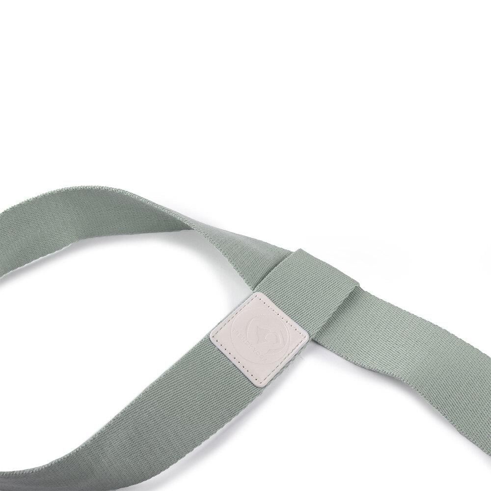 Nahaufnahme eines mintgrünen Yogamatten-Tragegurts aus Stoff mit einem kleinen Lederpatch und sichtbarer Naht.