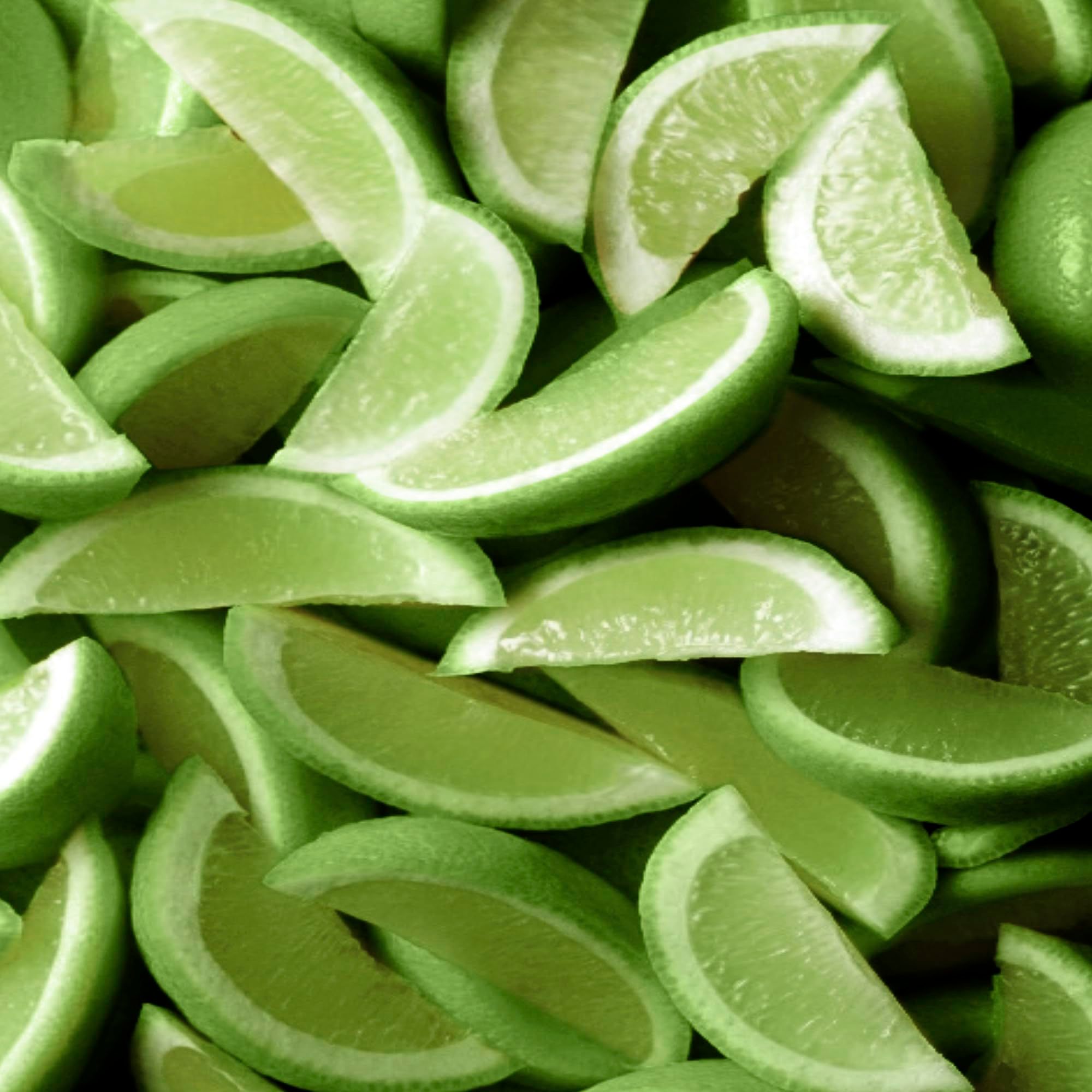 Nahaufnahme von Limettenscheiben. Die Scheiben sind grün und liegen dicht beieinander.