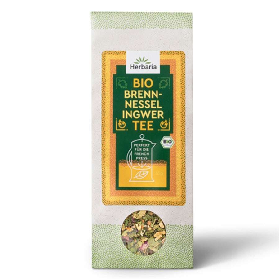 Verpackung mit Herbaria Bio Brennnessel Ingwer Tee. Sichtbares Logo, Produktbezeichnung und Bio-Siegel. Sichtfenster mit Tee.