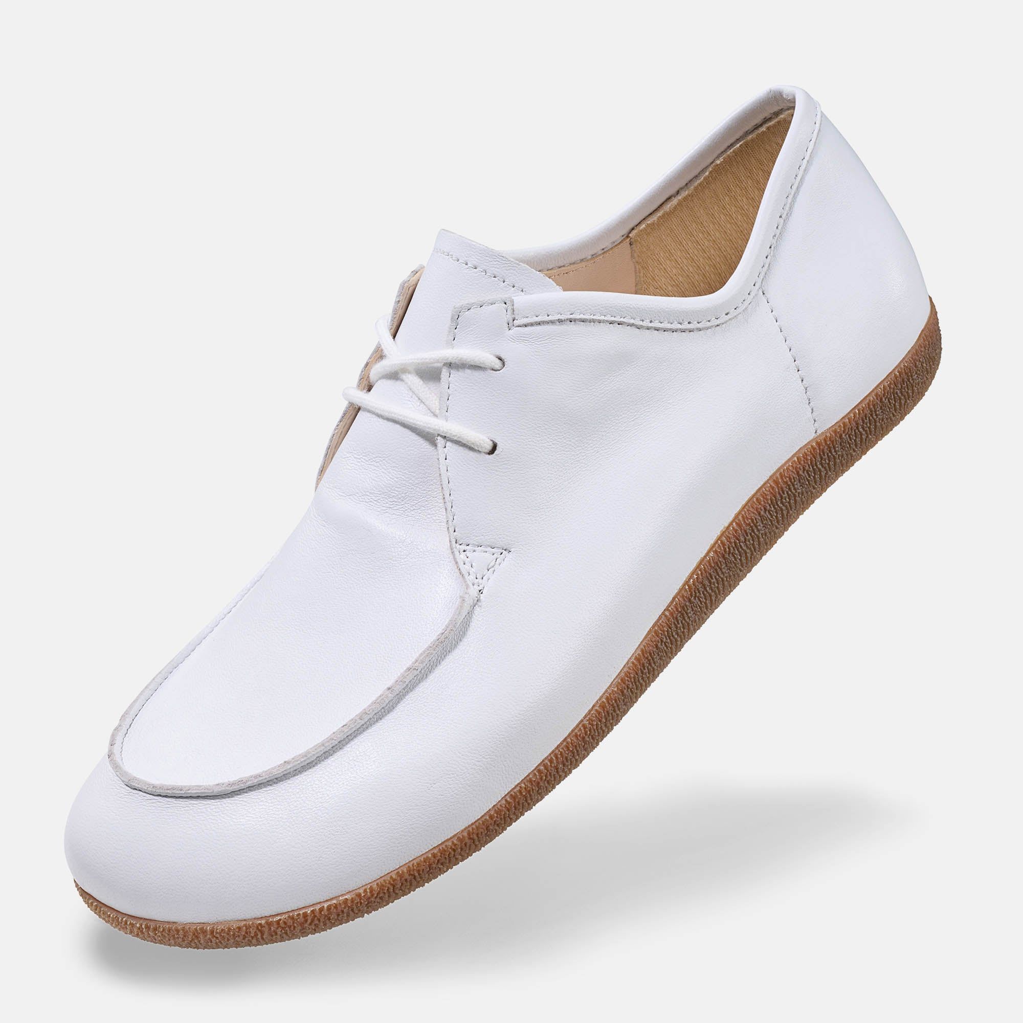 Weiße Schnürschuhe mit breiter Passform. Obermaterial aus Leder, helle Schnürsenkel, braune Sohle. Schuh, seitliche Ansicht.
