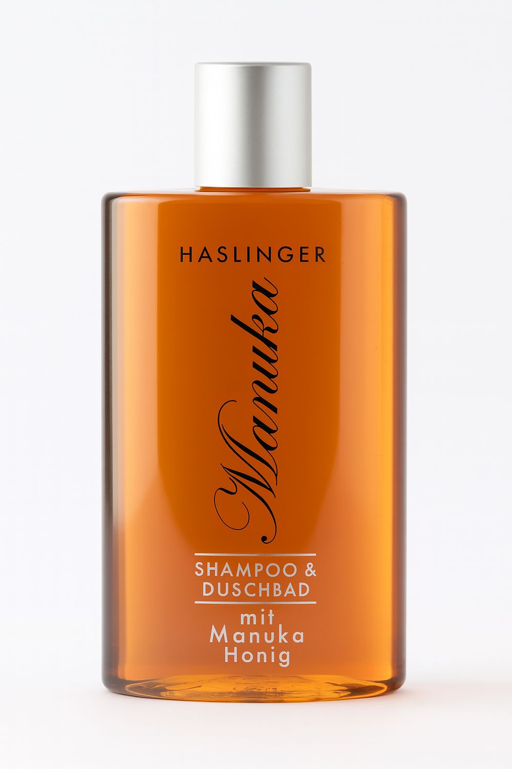 Rechteckige Flasche mit silbernem Deckel. Aufschrift: HASLINGER, Manuka, Shampoo & Duschbad, mit Manuka Honig.