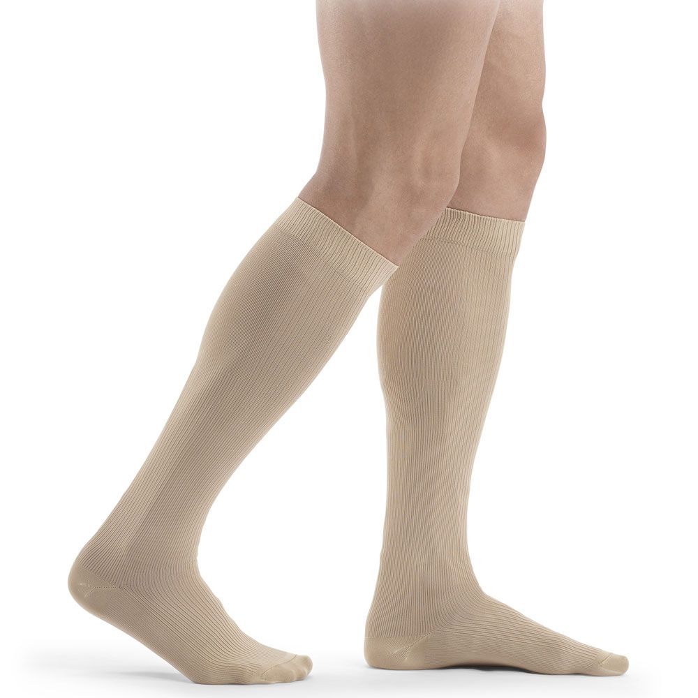Beige Kompressionsstrümpfe, Kniestrümpfe, geripptes Design. Auf Beinen getragen, von der Seite gesehen.