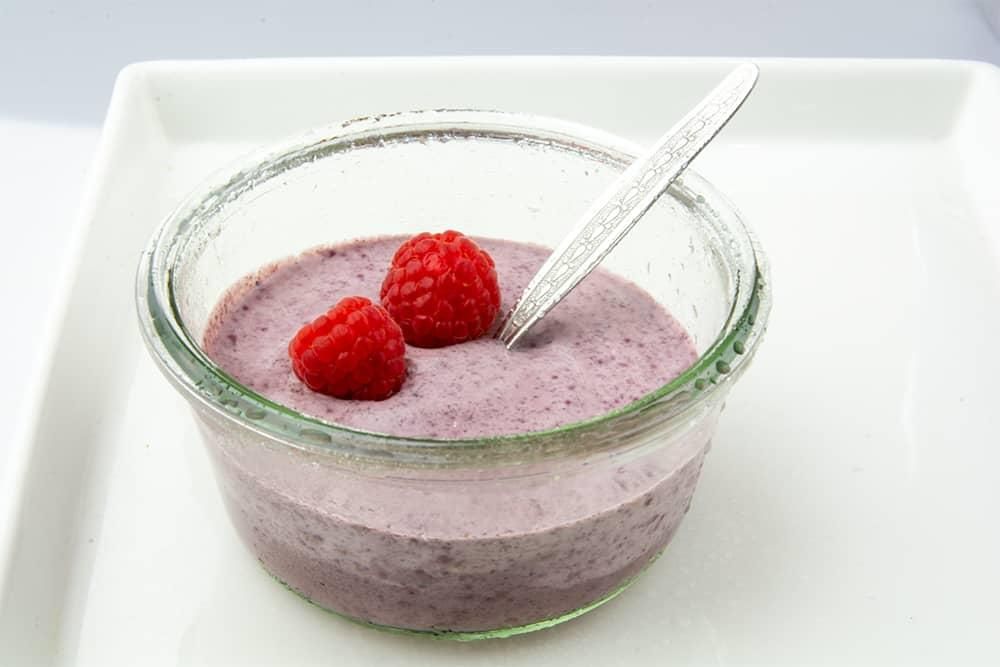 Dessert mit Himbeeren in Glas. Kräuterkontor Açaí.