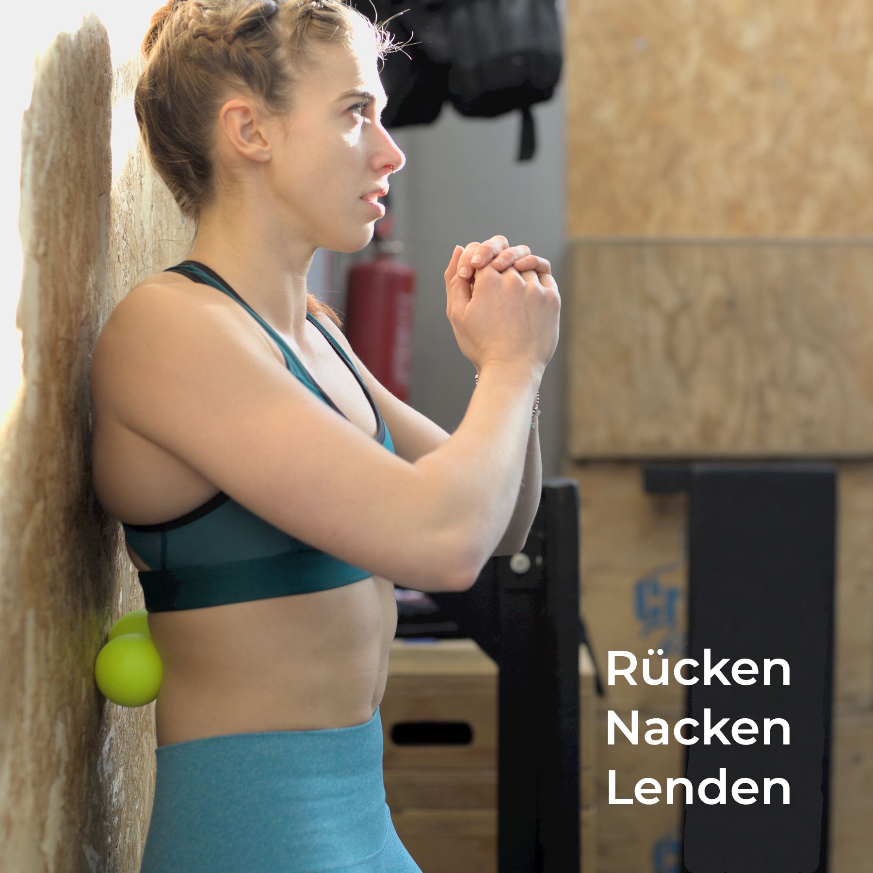 Hand hält Smartphone mit E-Book 'Massage Ball Set Exercises Guide'.