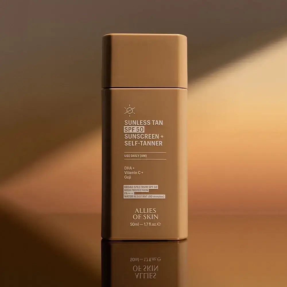 Flasche mit ALLIES OF SKIN Sunless Tan SPF 50 Sonnenschutz und Selbstbräuner, im goldenen Licht.