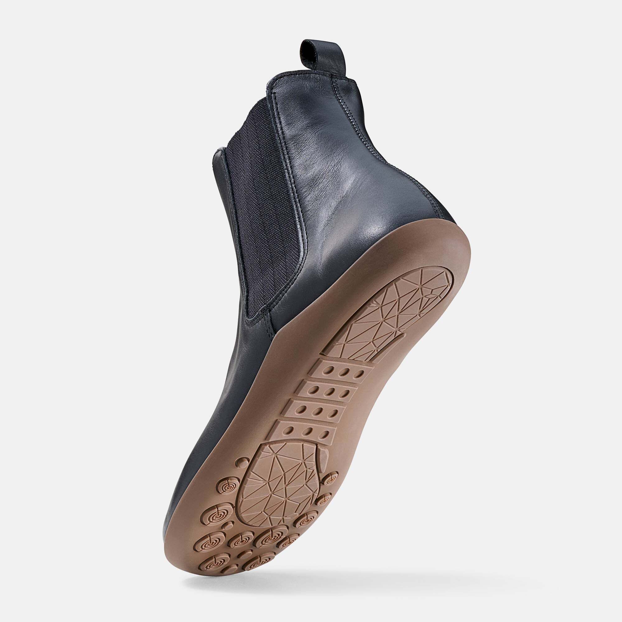 Dunkelblauer Chelsea-Stiefel aus Leder mit Gummisohle und elastischen Seiten. Zeigt die Sohlenansicht mit Muster.