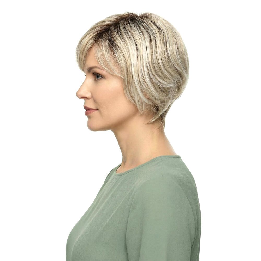 Kurzhaarperücke mit blonden Strähnen. Seitenansicht einer Frau mit grünem Oberteil.