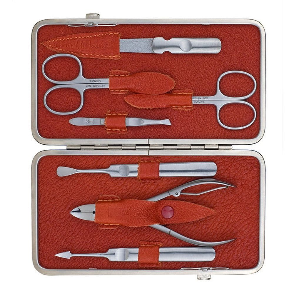 Offenes rotes Etui mit Maniküre-/Pediküre-Werkzeugen. Enthalten: Schere, Feile, Pinzette, Nagelhautschieber, Nagelknipser.