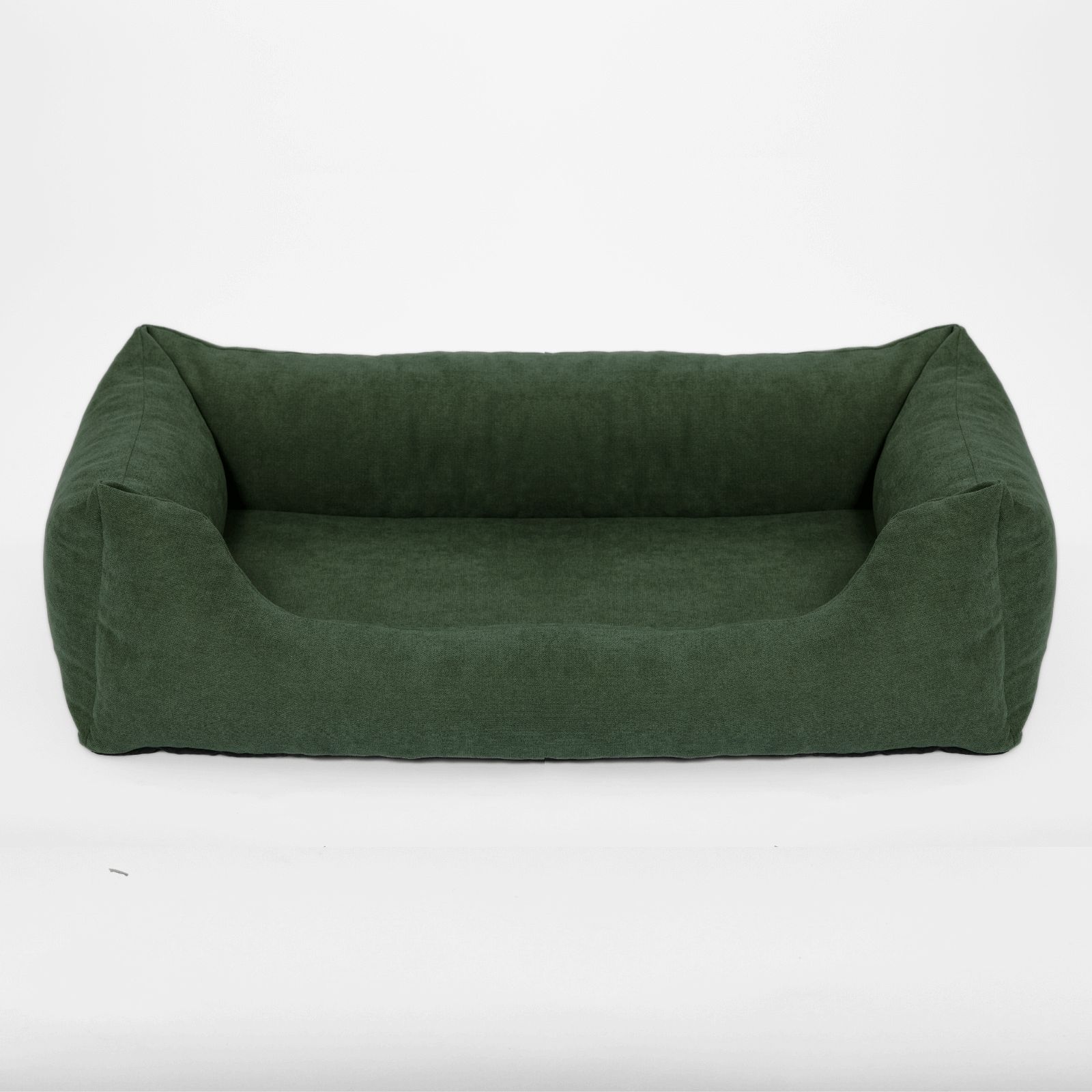Grünes Hundebett mit erhöhten Seiten. Rechteckige Form, weiches Material. Auf hellem Hintergrund.