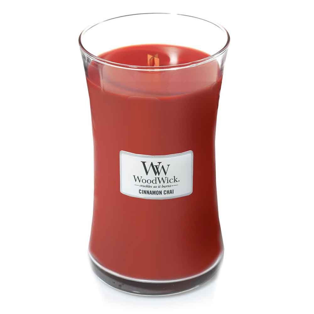 Rote Kerze in Glasbehälter. Aufkleber mit "WoodWick Cinnamon Chai".