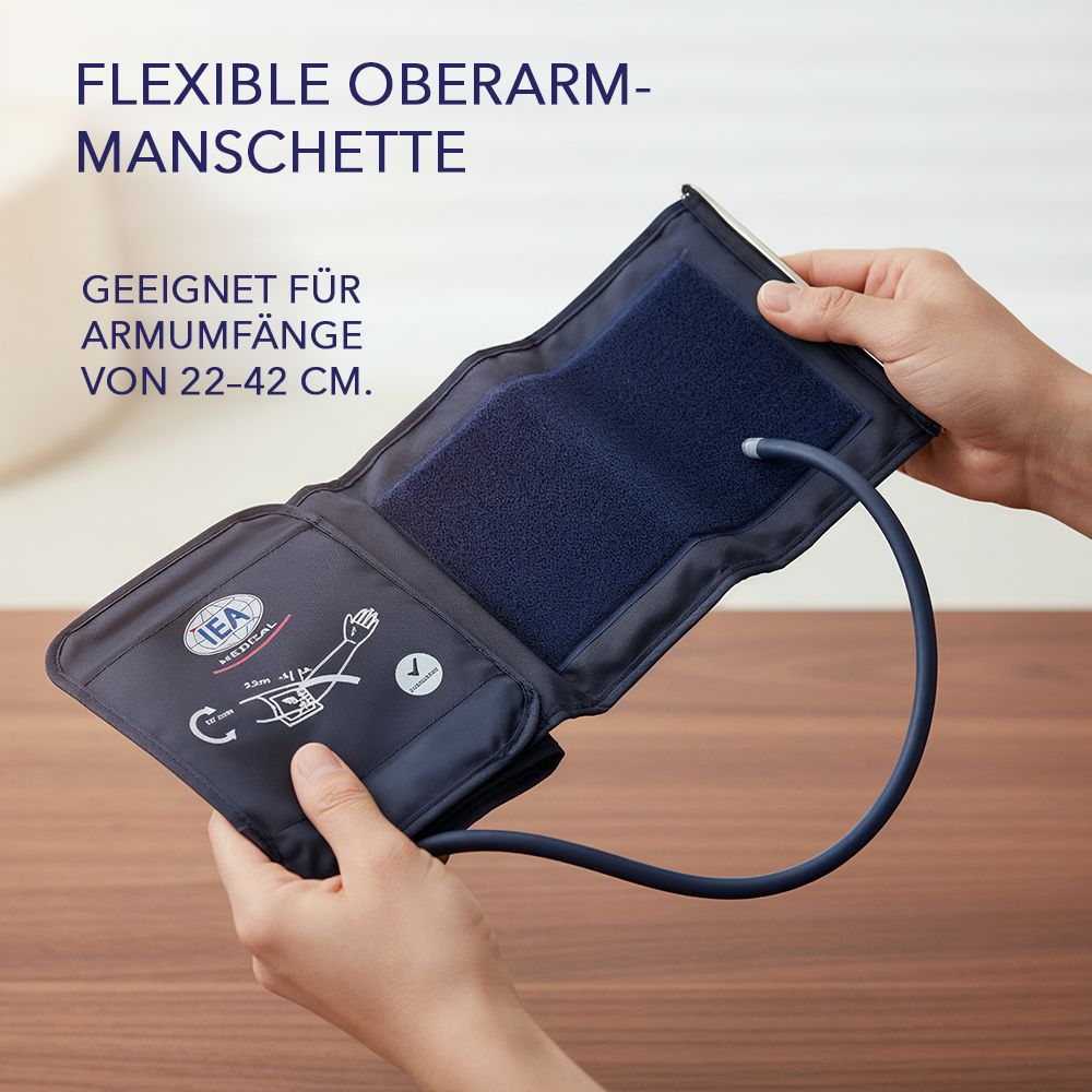 Hände halten eine offene Oberarmmanschette. Text: Flexible Oberarmmanschette. Geeignet für Armumfänge von 22-42 cm. IEA Logo.