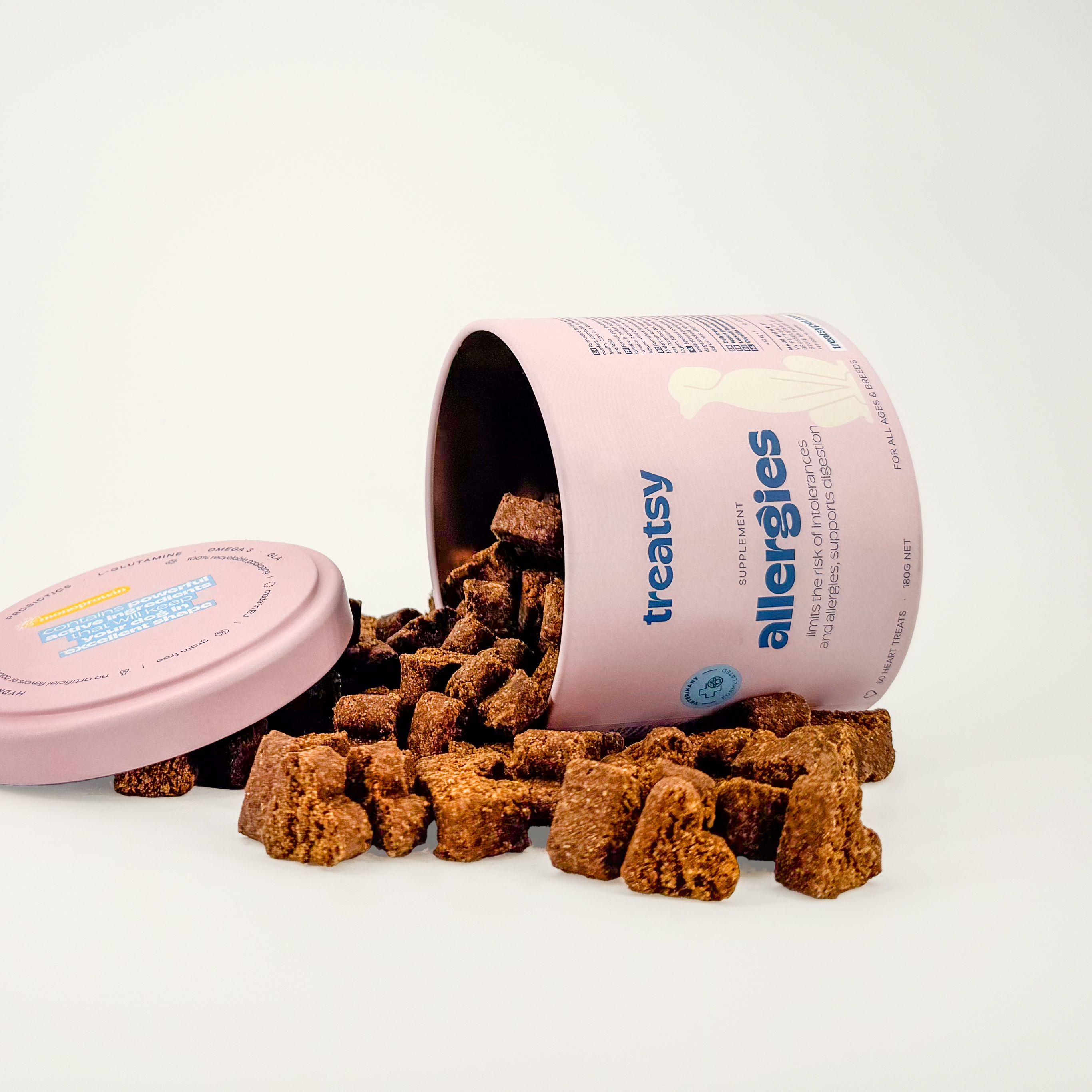 Rosa Dose mit „Treatsy Allergies“ für Hunde, umgekippt. Herzförmige Leckerlis daneben.