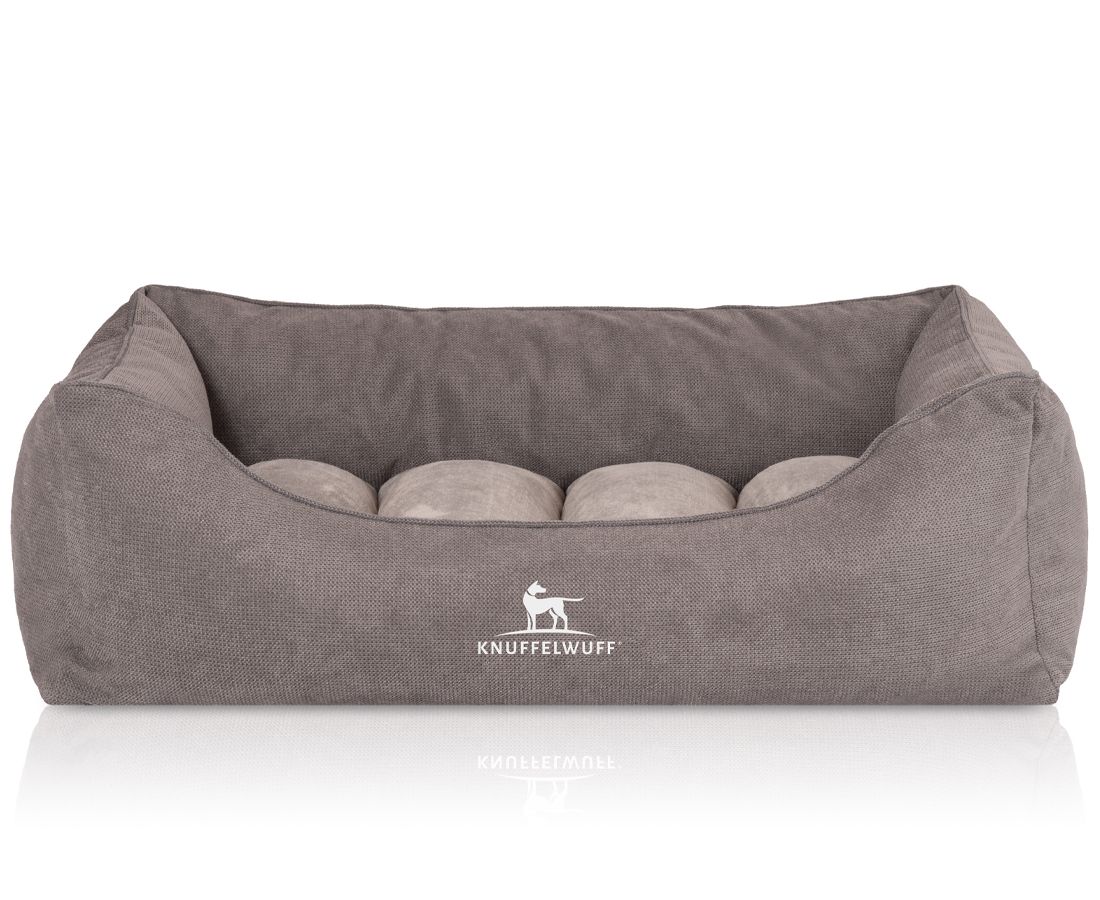 Orthopädisches Hundebett in Grau. Rechteckige Form mit erhöhten Seiten und vier Kissen. Logo "Knuffelwuff" unten.