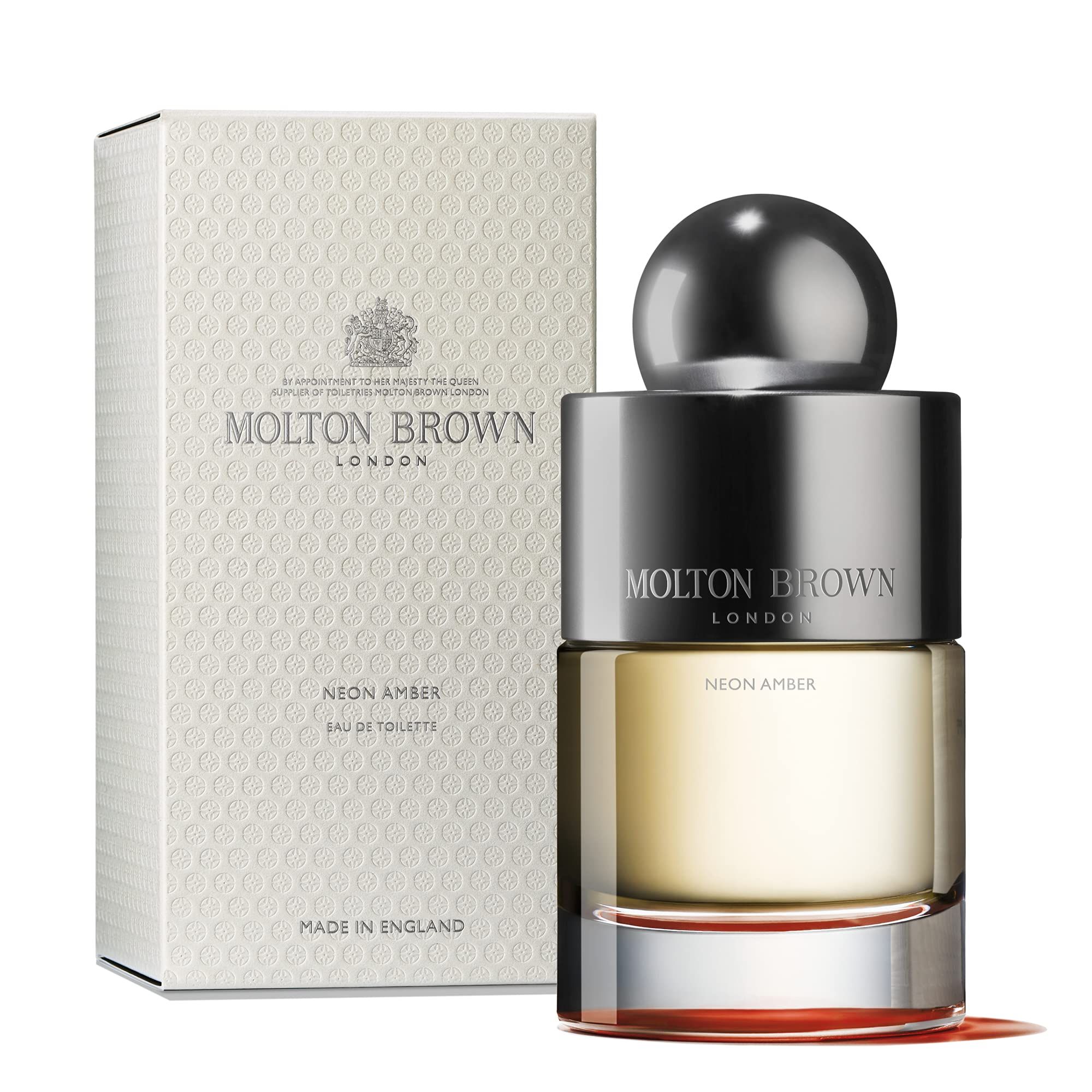 Molton Brown Neon Amber Eau de Toilette Flakon und Verpackung. Flakon mit silbernem Deckel, neben weißer Schachtel.