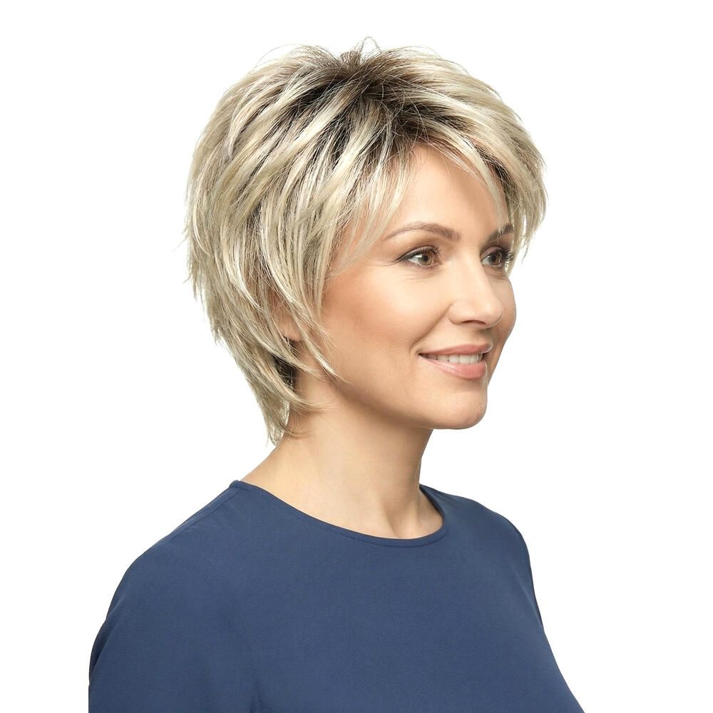 Blond gefärbte Perücke mit kurzem, gestuftem Schnitt. Frau mit blauem Oberteil, Dreiviertelansicht.