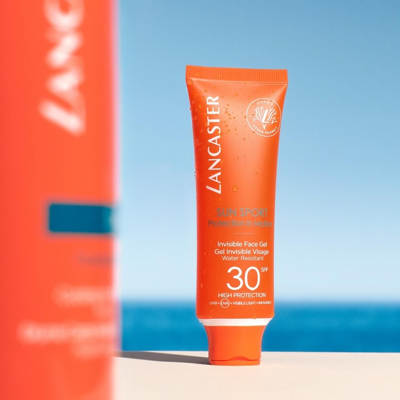Orange Tube Lancaster Sun Sport Invisible Face Gel SPF30. Vor blauem Himmel.