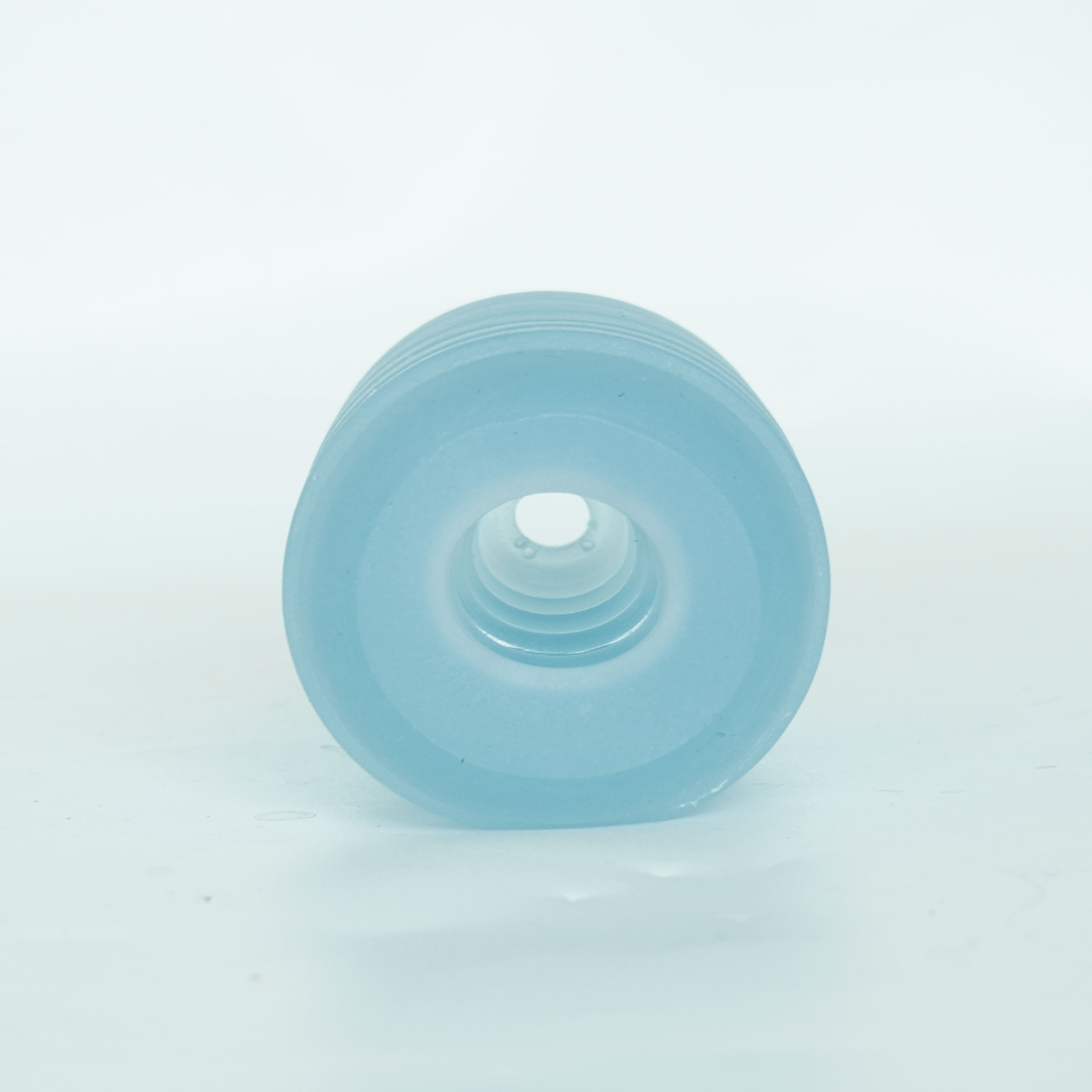 Blaues Silikonprodukt mit Öffnung. Mehrere Ringe sichtbar. Auf weißem Hintergrund.