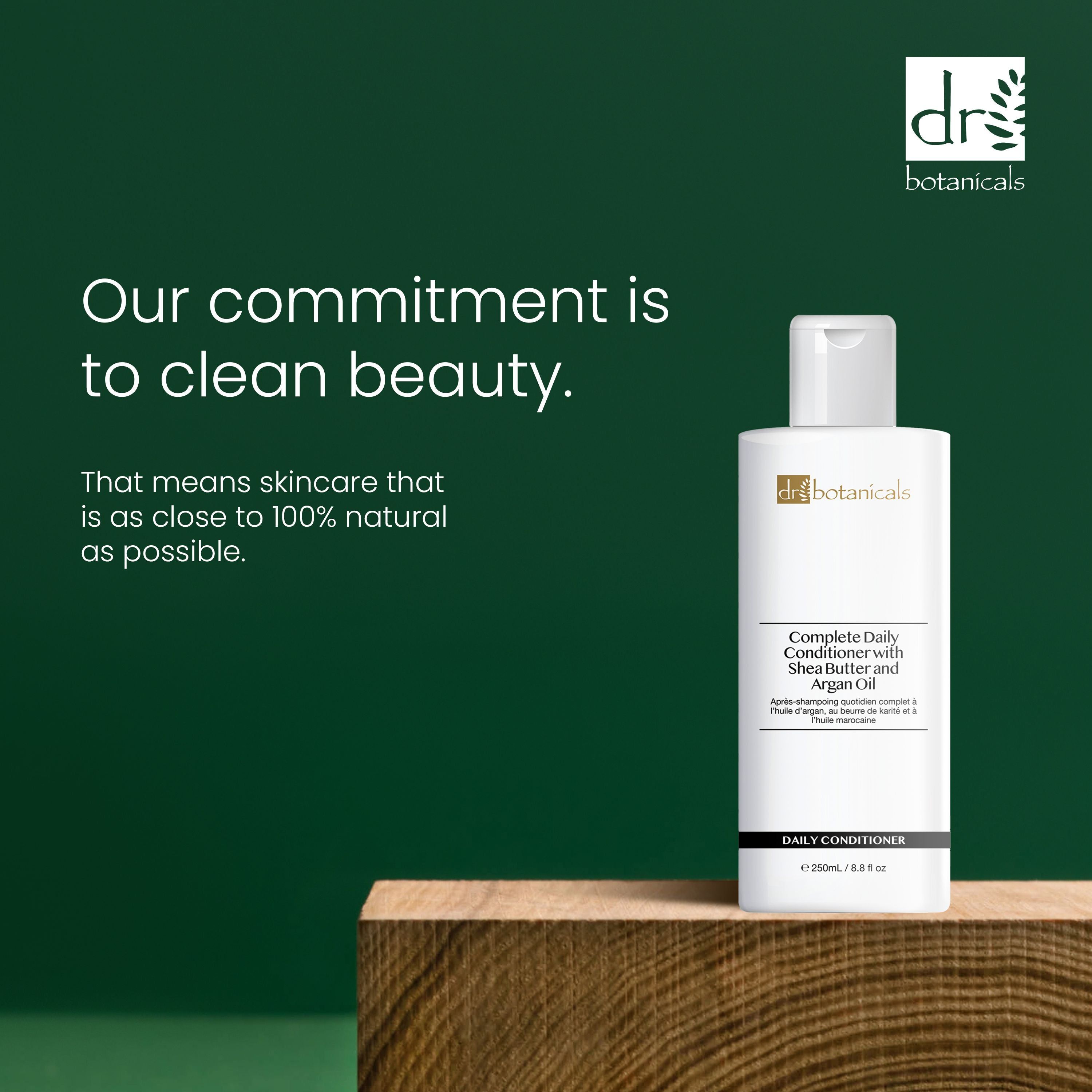 Flasche Conditioner auf Holzblock. Text: Complete Daily Conditioner with Shea Butter and Argan Oil. Marke: dr. botanicals. Text: Clean Beauty.