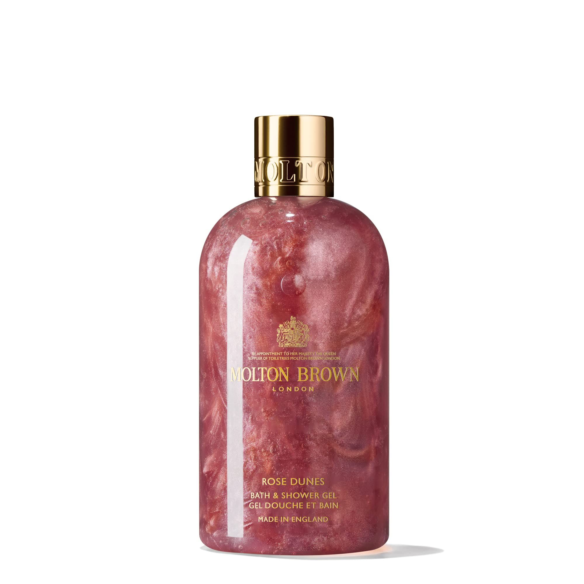 Molton Brown Rose Dunes Duschgel-Flasche. Rosa Flüssigkeit, goldener Deckel. Text: Rose Dunes, Bath & Shower Gel.