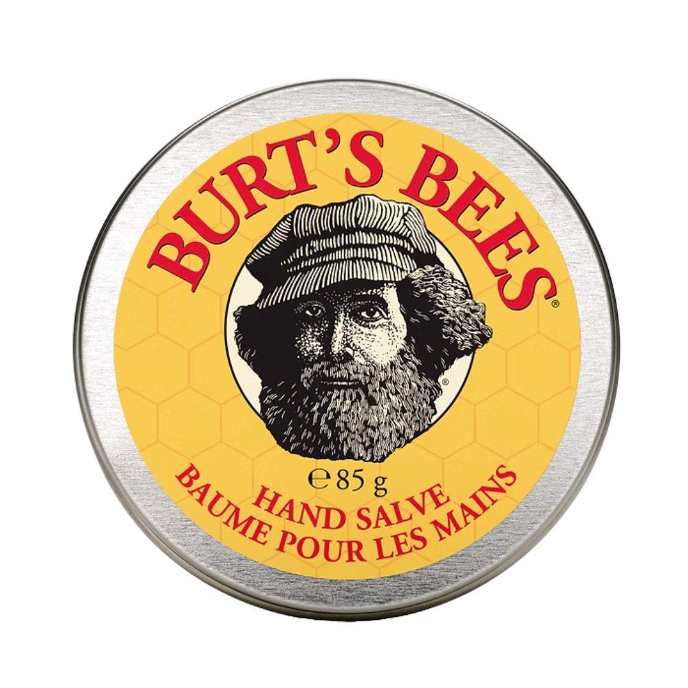 Runde Dose mit gelbem Etikett und Aufschrift BURT'S BEES. Abbildung eines Mannes mit Bart und Hut. Text: Hand Salve, Baume pour les mains.