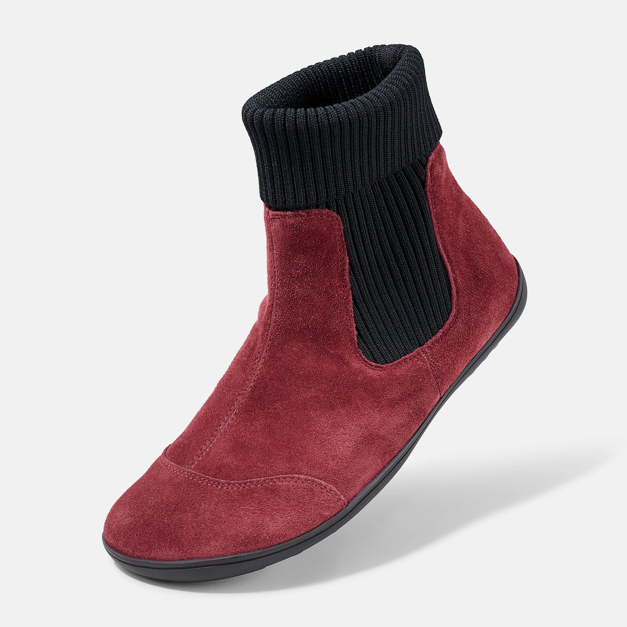 Rote Stiefelette mit schwarzem, geripptem Schaft. Flache Sohle. Obermaterial aus Wildleder. Seitenansicht.