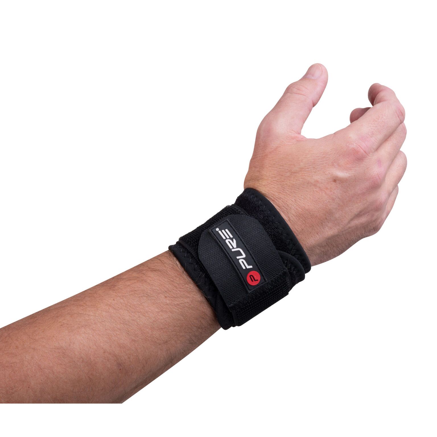 Una persona indossa un tutore per polso Pure2Improve in neoprene nero. Il prodotto è fissato al polso e ha una chiusura in velcro. Il logo Pure e una 'R' rossa sono visibili. Il prodotto è progettato per il supporto del polso.