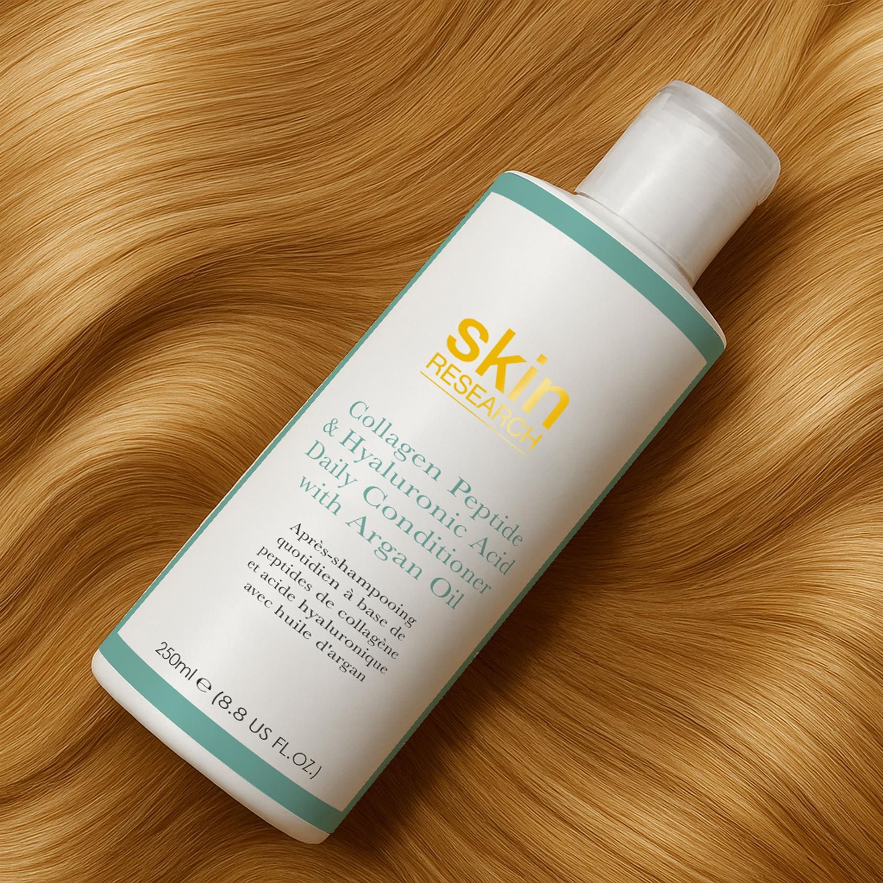 Skin Research Tägliche Pflegespülung mit Kollagenpeptiden, Hyaluronsäure und Arganöl, Flasche auf blondem Haar.