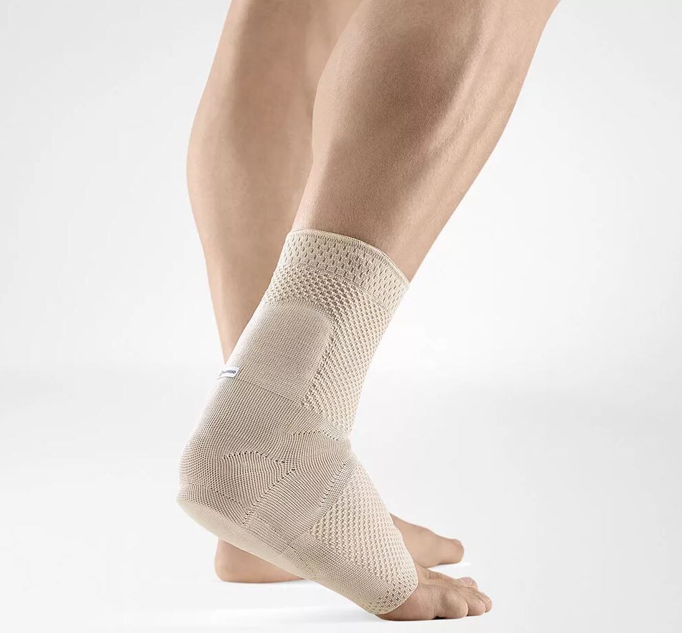 Beige Knöchelbandage am Bein. Gewebtes Material, rechteckiger Bereich, weißes Detail.