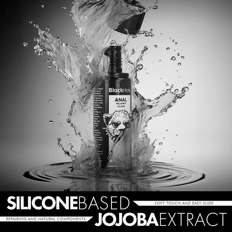 Schwarze Flasche mit Anal Relaxing Jojoba Extrakt, umgeben von Wasserspritzern.
