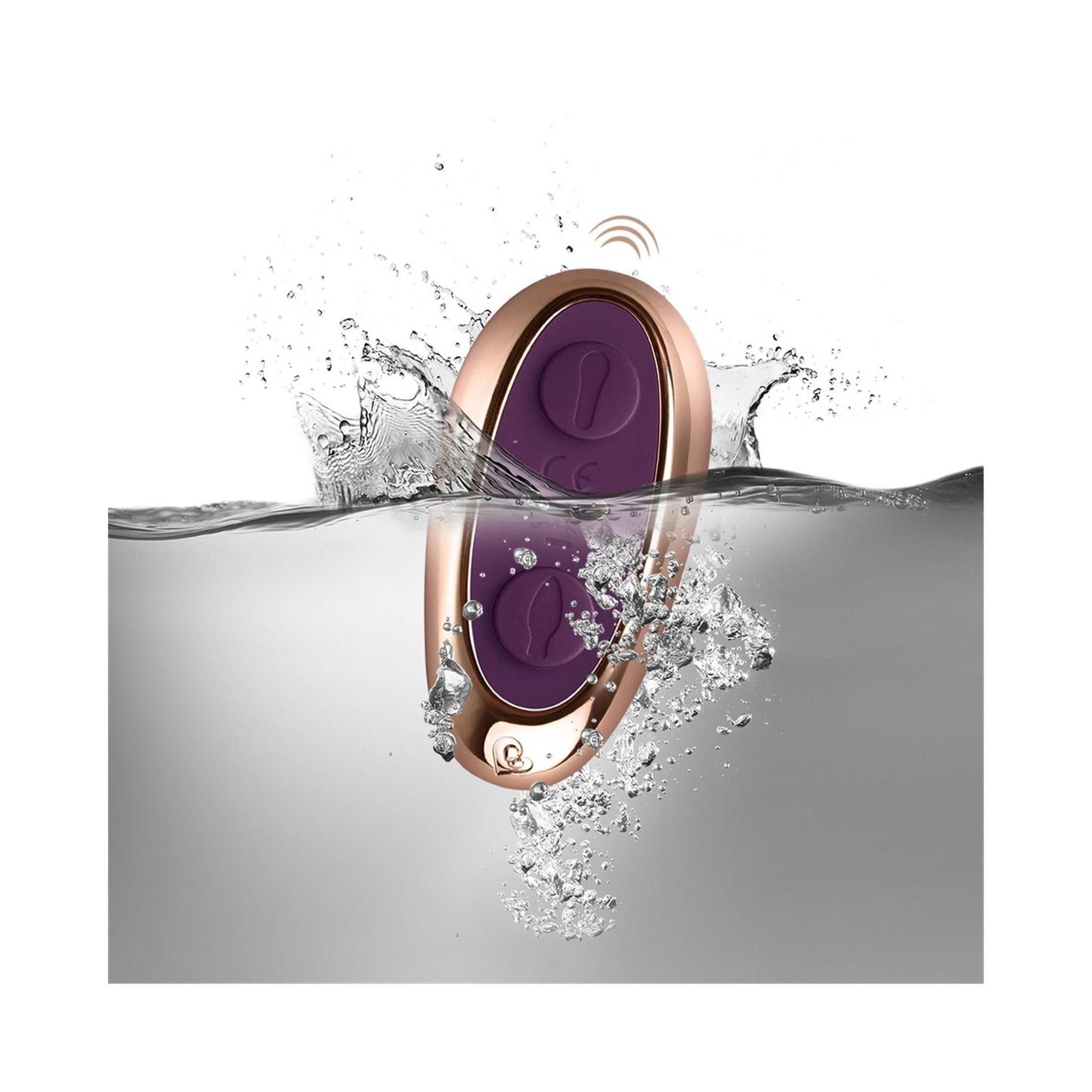 Goldfarbene Fernbedienung im Wasser. Lila Knöpfe, CE-Zeichen. Wasser spritzt. Drahtloses Symbol.