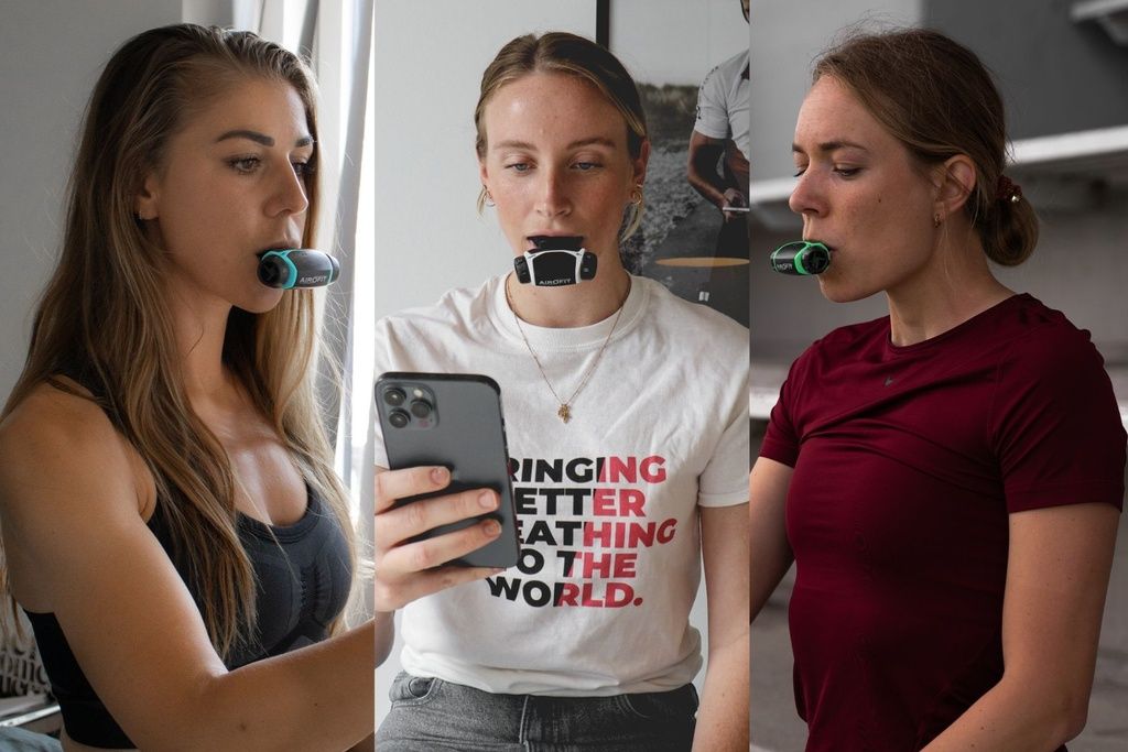 Drei Frauen mit Atemtrainern im Mund. Eine Frau benutzt ein Smartphone.