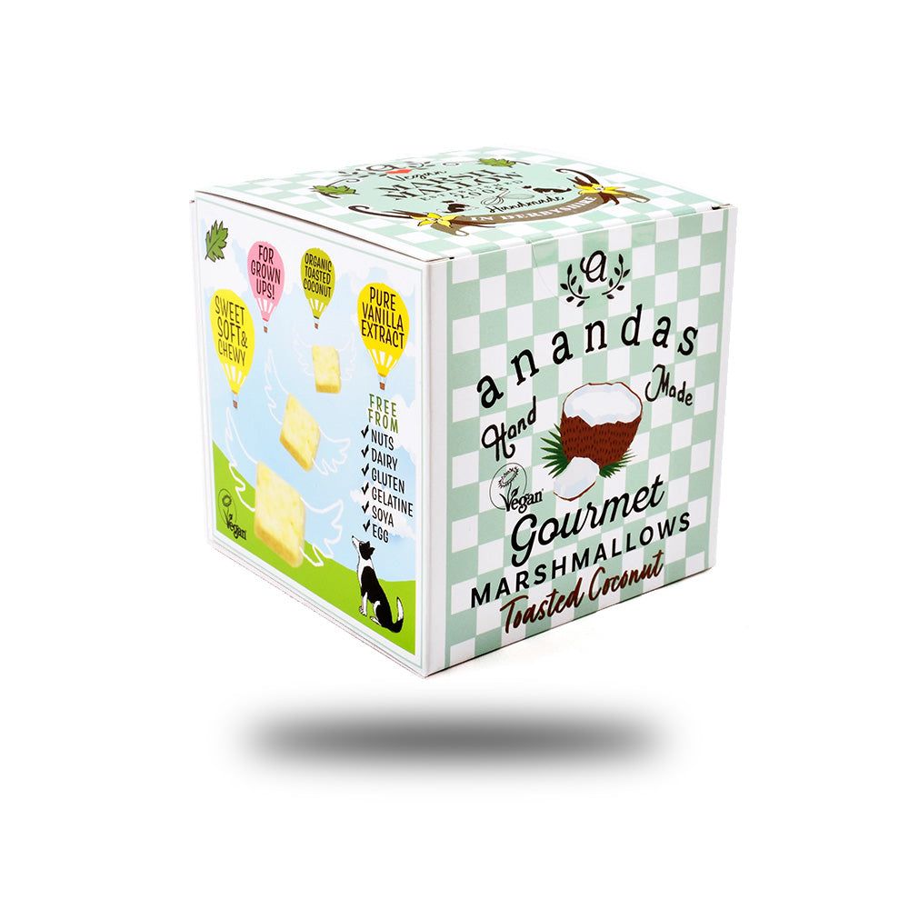 Quadratische Verpackung mit Ananda Foods-Logo und Aufschrift "Gourmet Marshmallows". Enthält Kokosnuss-Illustration und Angaben zu Inhaltsstoffen.
