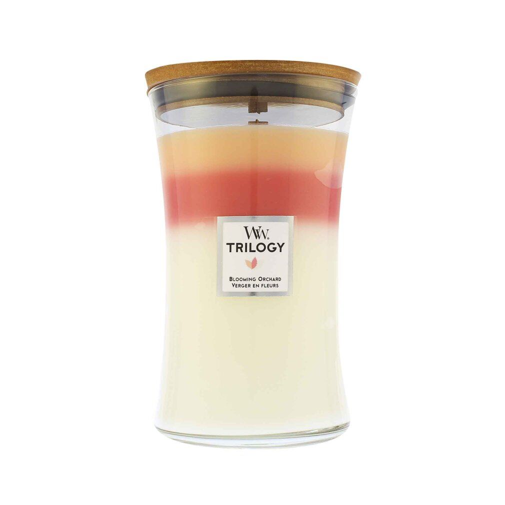 Dreifarbige Duftkerze mit Holzdocht. Glasbehälter mit Deckel. Etikett mit "Trilogy" und "Blooming Orchard".