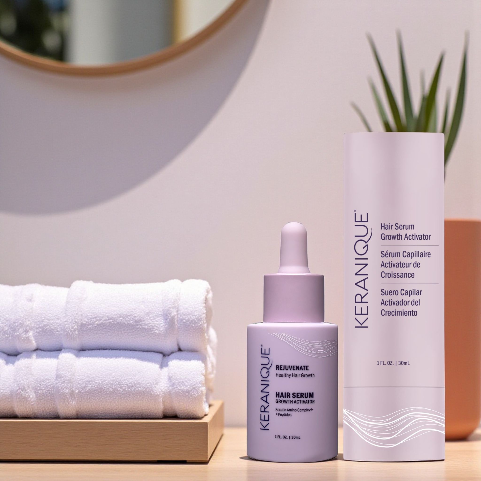 Flasche und Serumflasche. Aufschrift: KERANIQUE, Hair Serum Growth Activator, 1 fl. oz. | 30ml. Daneben Handtücher.