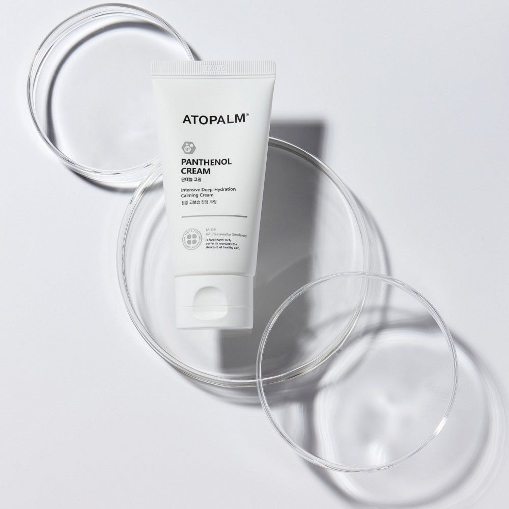 Weiße Tube auf Glasplatten. ATOPALM-Logo und Produktbezeichnung: PANTENOL CREAM, Intensive Deep-Hydration Calming Cream.