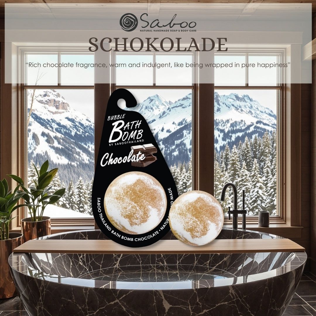 Zwei Bad Bomben, Schokolade, auf Holzablage. Hintergrund: Fenster mit Berglandschaft. Text: Bubble Bomb by Saboo Thailand.