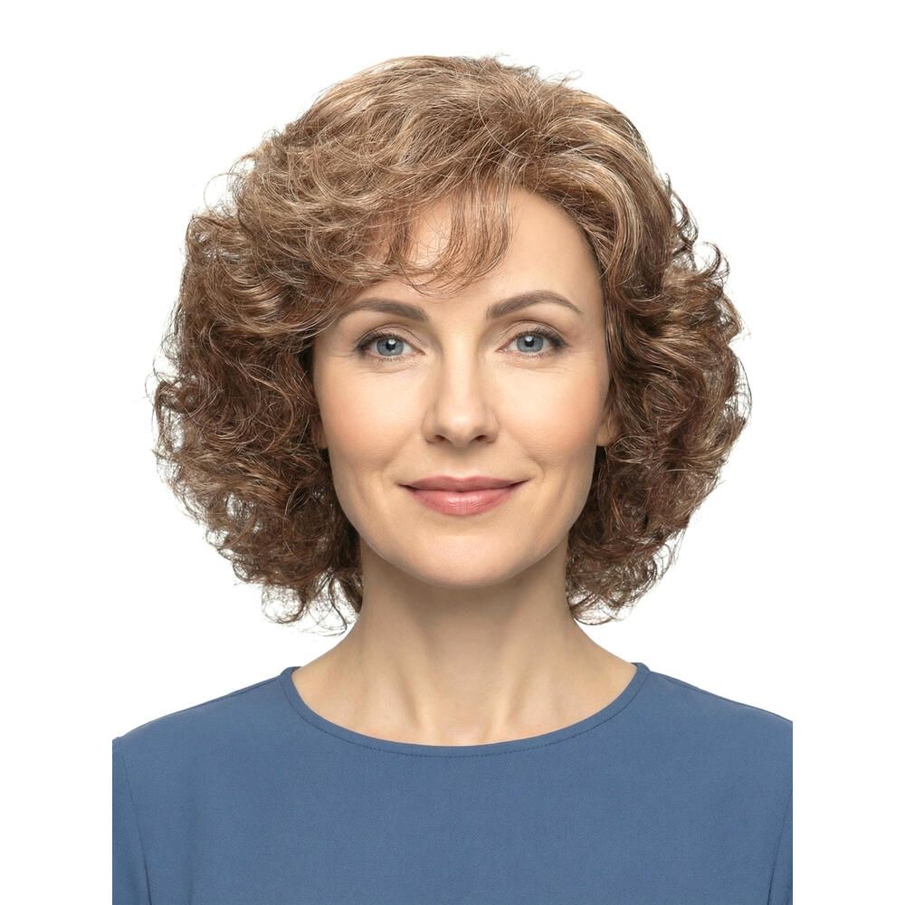 Perücke mit lockigem, braun-blondem Haar. Frontale Ansicht einer Frau mit blauem Oberteil. Blick in die Kamera.
