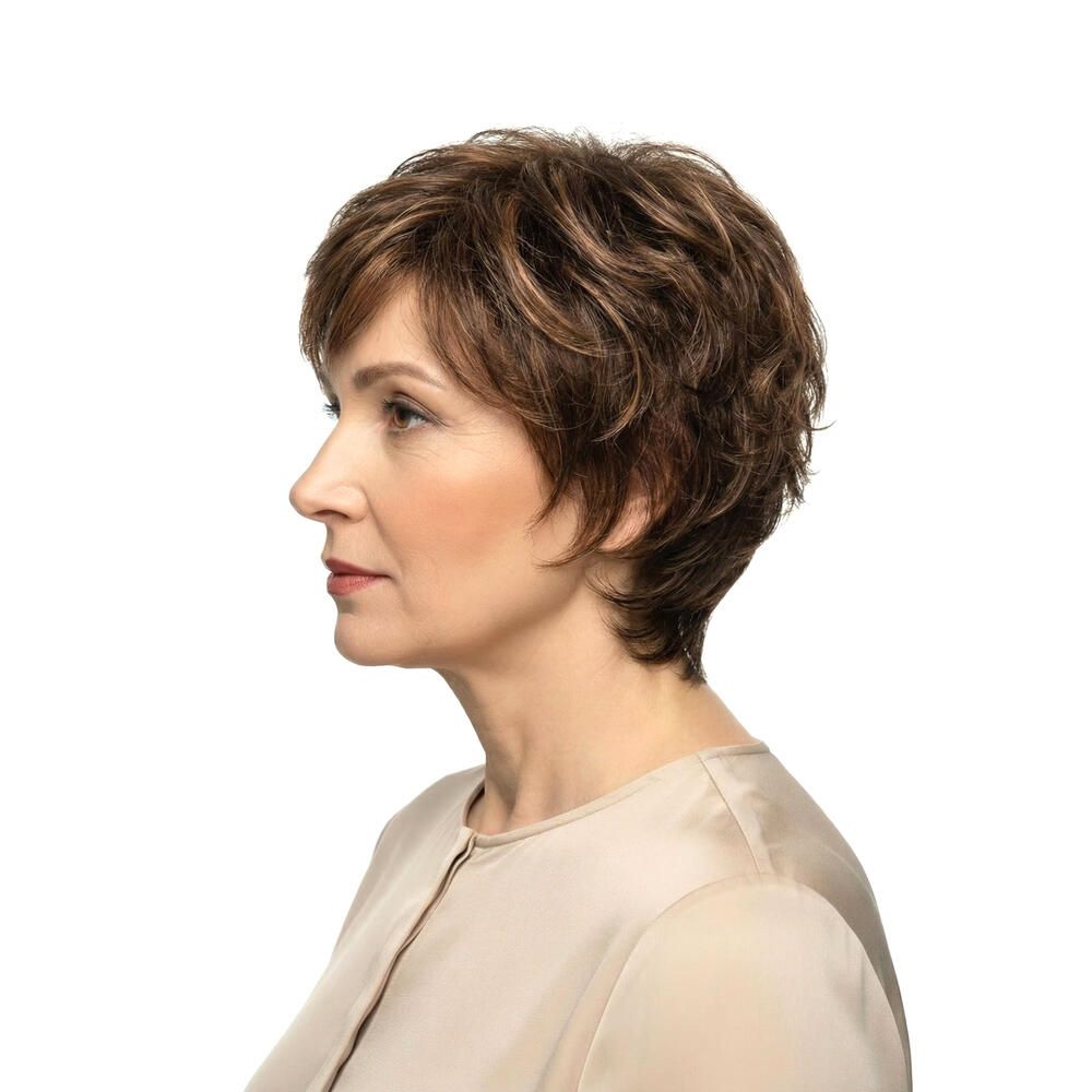 Kurzhaarperücke, braun, mit Pony. Frau trägt beigefarbenes Oberteil. Profilansicht.
