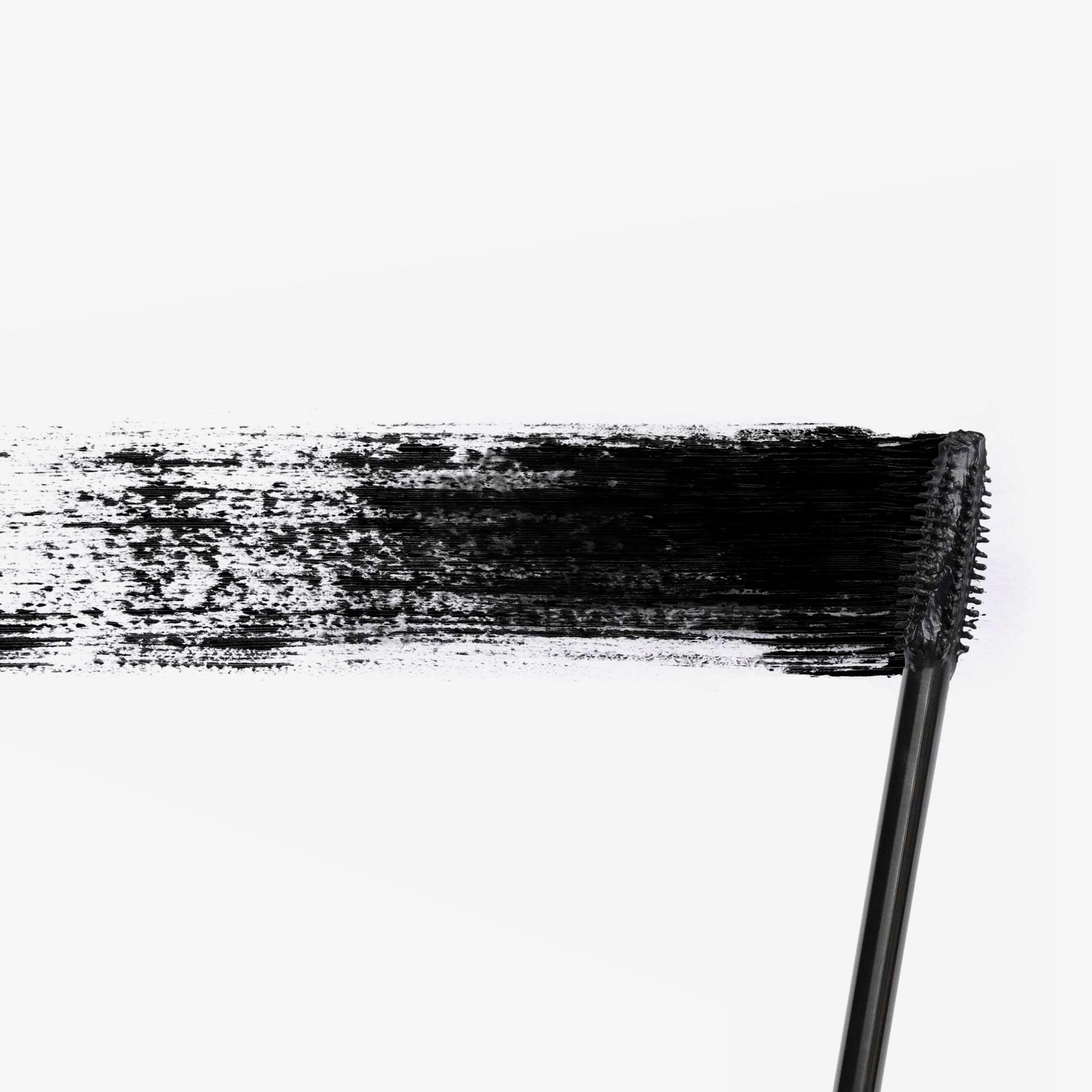 Schwarze Mascarabürste, die einen schwarzen Strich auf weißem Hintergrund hinterlässt.