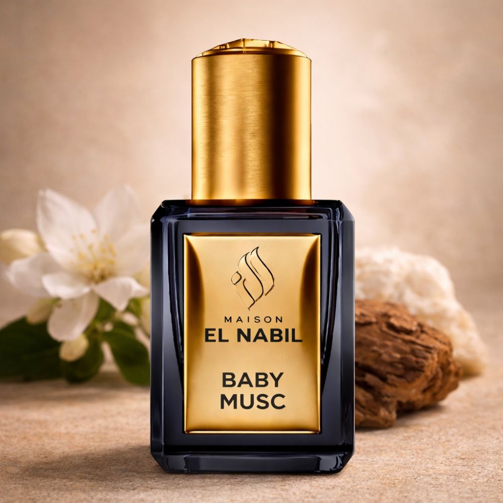 Schwarze Flasche mit goldener Kappe. Goldfarbenes Etikett mit Logo und Schriftzug BABY MUSC. Neben Blüten und Holz.
