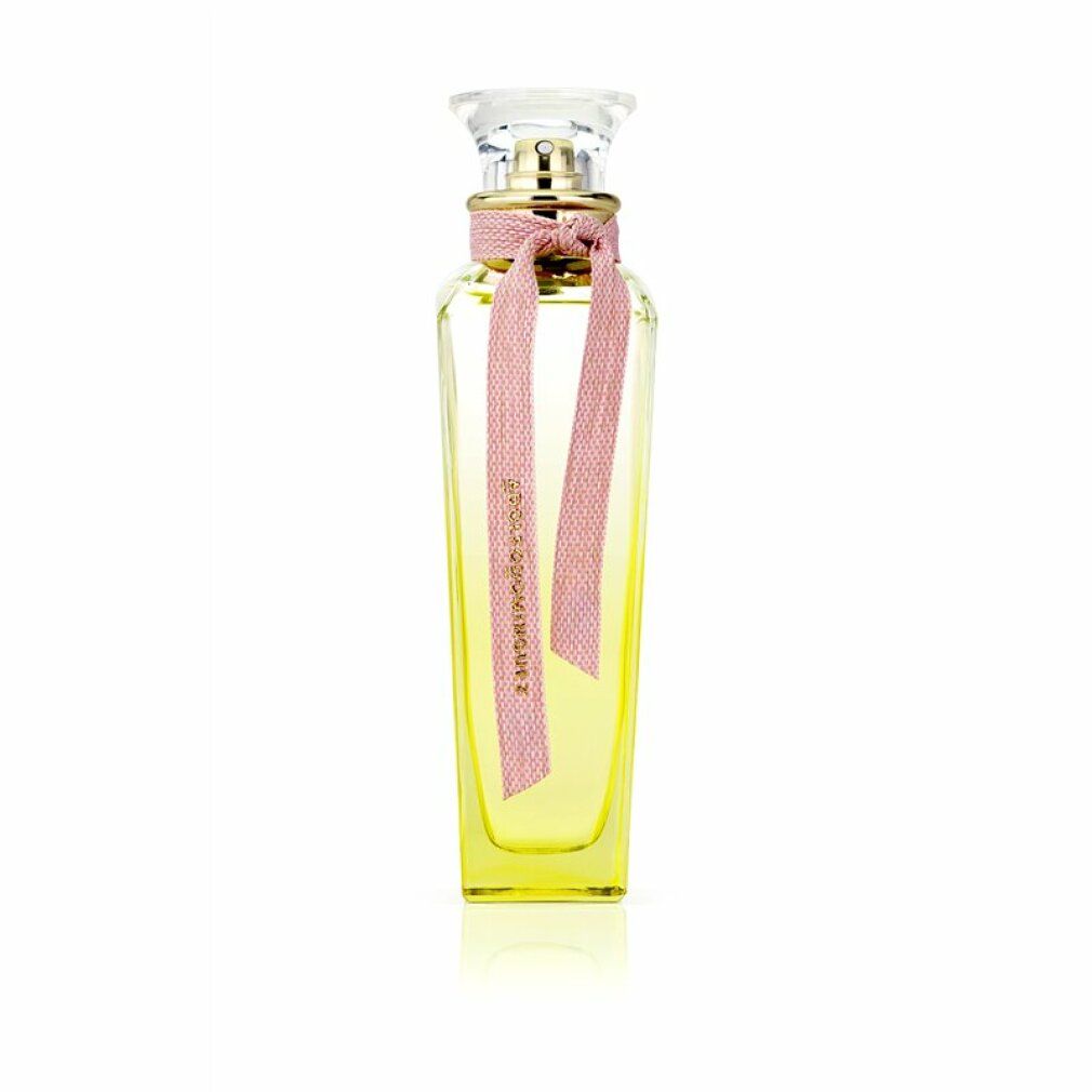 Parfümflakon mit gelblicher Flüssigkeit. Rosa Schleife mit Aufschrift Adolfo Dominguez. Klarer Glasverschluss.