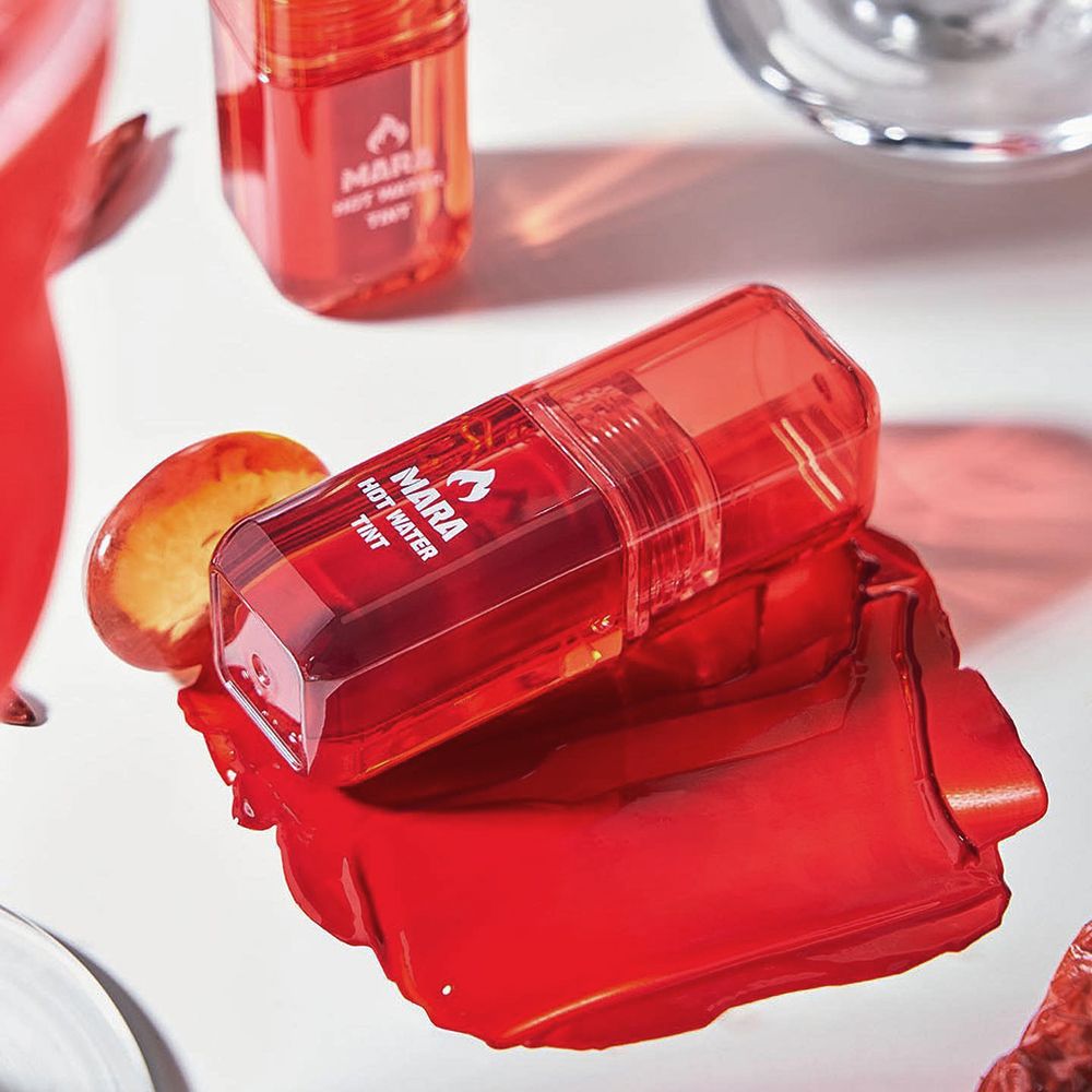 Roter Lip Tint und Farbfleck. MARA HOT WATER TINT-Logo. Produkt auf weißem Hintergrund.