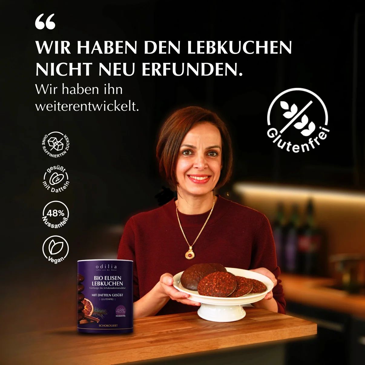 Frau mit Lebkuchen und Dose mit der Aufschrift "Edilia Bio Elisen Lebkuchen".