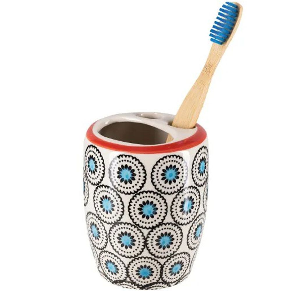 Keramischer Zahnbürstenhalter mit blau-schwarzem Kreis-Muster und rotem Rand. Ein Bambuszahnbürste ist eingesetzt.