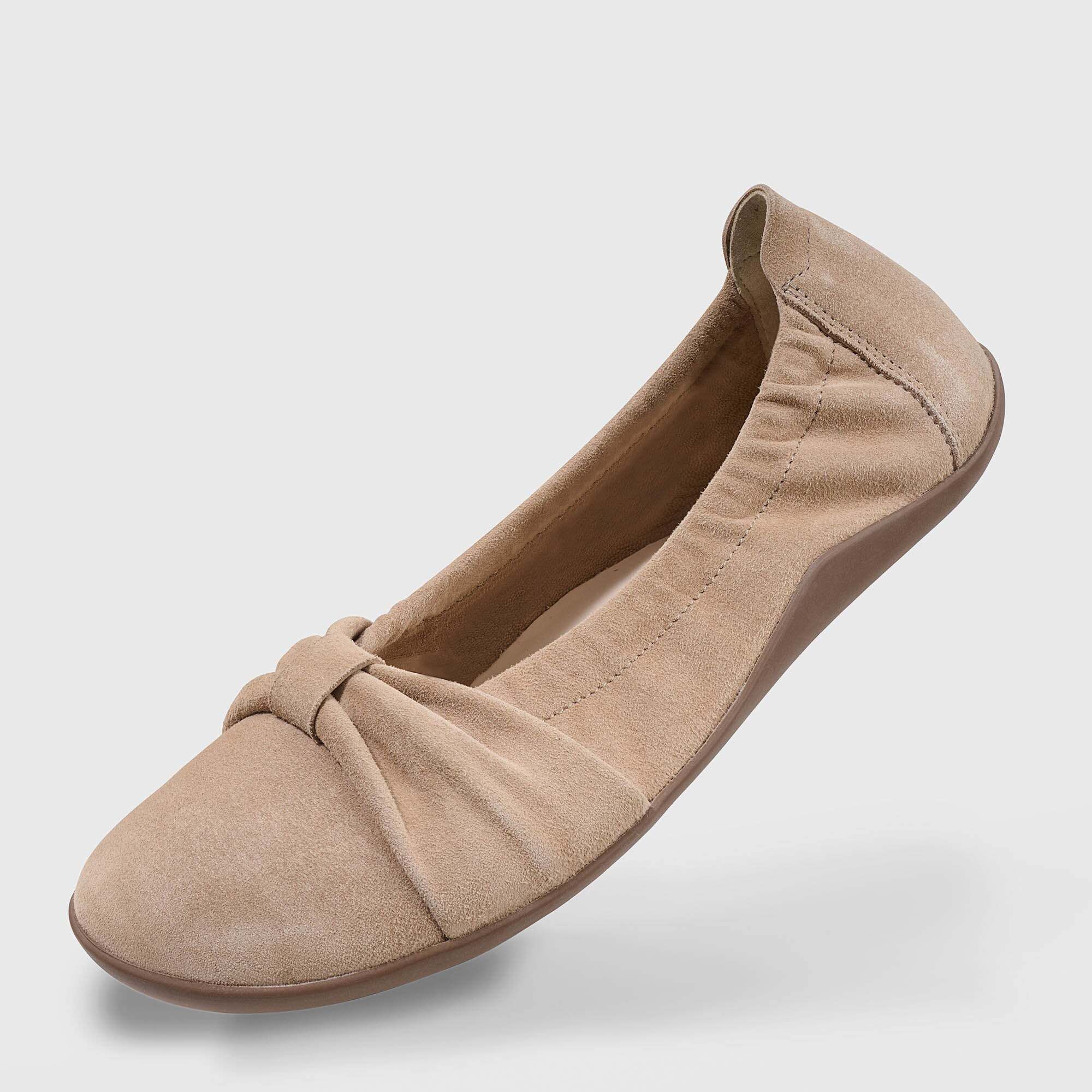 Beige Wildleder Ballerina mit Schleifenverzierung, schräg von vorne.