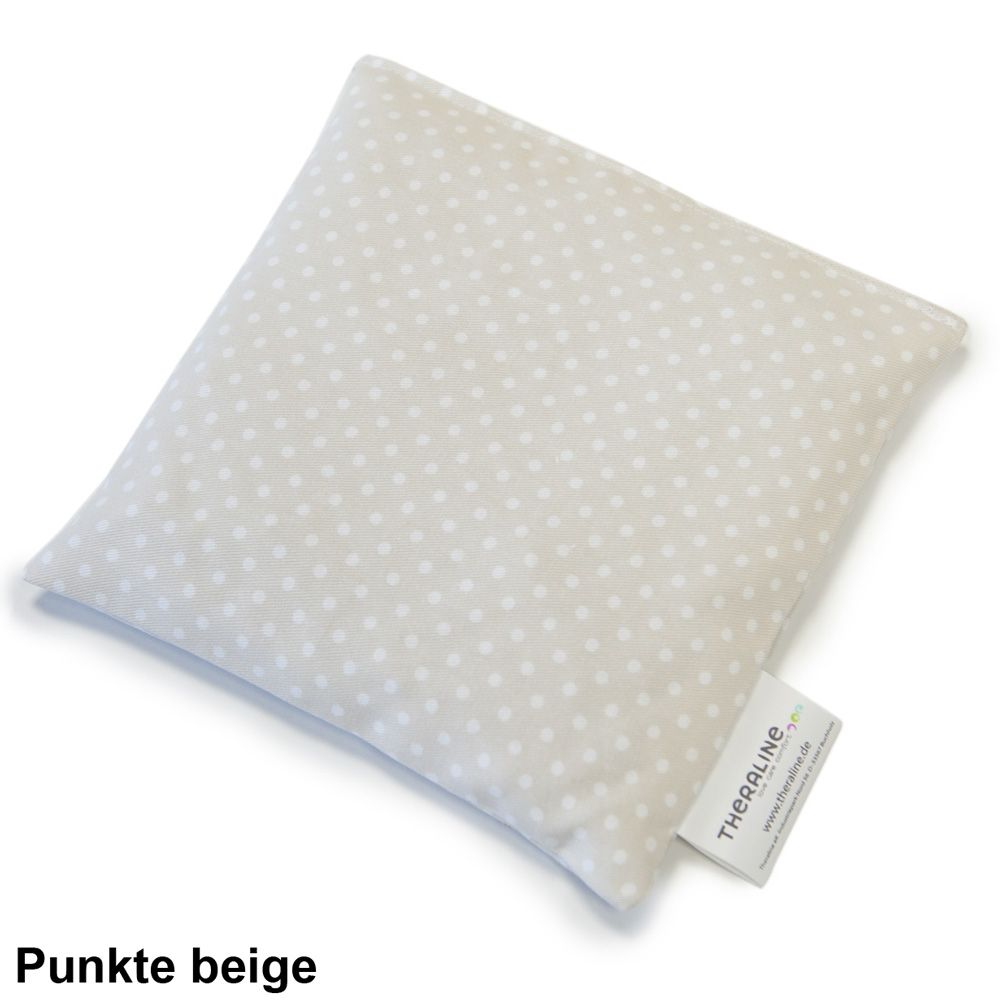 Quadratisches Kissen mit weißen Punkten auf beigefarbenem Stoff. Mit Etikett.